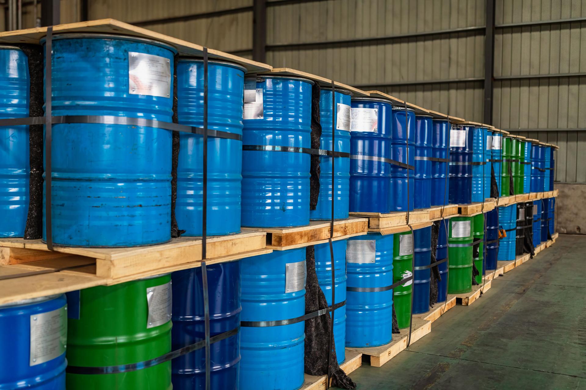 Blue Metal Oil Barrels Stacked In A Warehouse